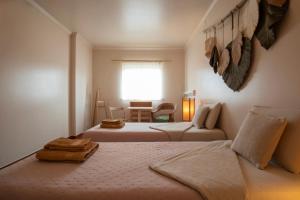 a bedroom with two beds and a window at BE LOST - Guest House in Pedra Do Ouro +14 photos