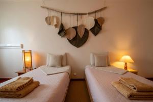two beds sitting next to each other in a room at BE LOST - Guest House in Pedra Do Ouro