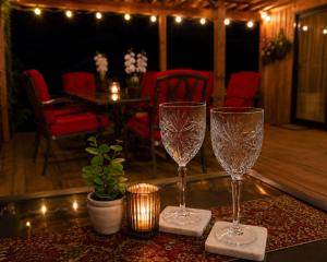 two wine glasses sitting on a table in a room at JAWS Retreat Bungalow in Haleiwa