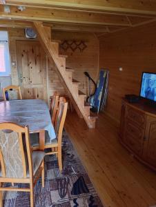 a dining room with a table and a staircase in a log cabin at Domek Olchowiec 2 Nad Soliną in Olchowiec