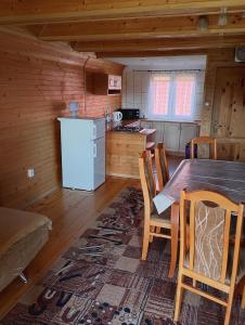 a kitchen with a table and chairs in a cabin at Domek Olchowiec 2 Nad Soliną in Olchowiec