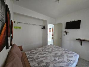a bedroom with a bed and a flat screen tv at Departamento en la Huertas in Barrio Nuevo