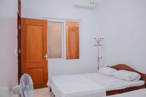 a white room with two beds and a mirror at Tám bảy in Cửa Lô