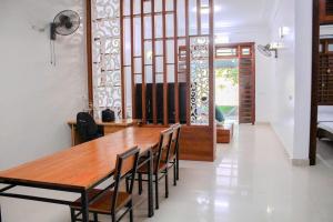 a dining room with a wooden table and chairs at Tám bảy in Cửa Lô
