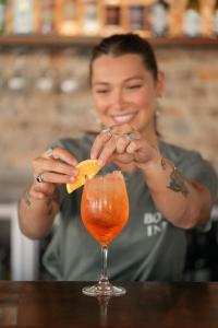 a woman sitting at a table with a drink at The Bolt Inn in Uralla