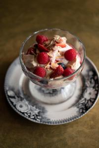 a glass bowl of dessert with strawberries on a plate at The Bolt Inn in Uralla