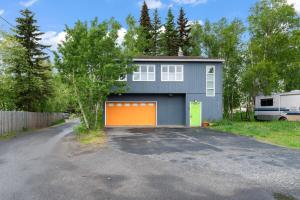 a house with an orange garage in the driveway at Close To Airport - Shared Space - Fast WI-FI in Anchorage