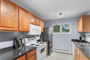 a kitchen with white appliances and wooden cabinets at Close To Airport - Shared Space - Fast WI-FI in Anchorage