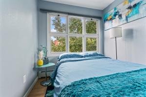 a bedroom with a blue bed and a window at Close To Airport - Shared Space - Fast WI-FI in Anchorage