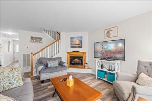 a living room with a fireplace and a tv at Whispering Pines in Black Point Landing