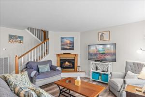 a living room with a couch and a fireplace at Whispering Pines in Black Point Landing