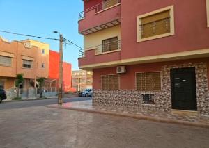 a red building on the side of a street at saidia 700 m de la plage in Saïdia