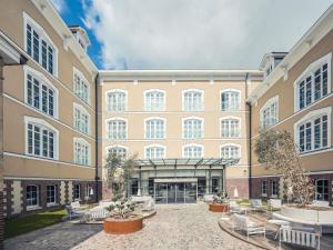 a large building with a courtyard with white chairs at Mercure Troyes Centre in Troyes