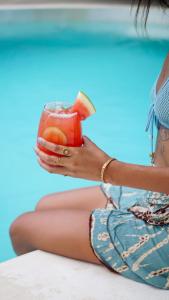 a woman sitting in a pool holding a drink at Happiness Boutique Resort El Nido in El Nido