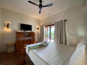 a bedroom with a bed and a ceiling fan at Happiness Boutique Resort El Nido in El Nido +95 photos