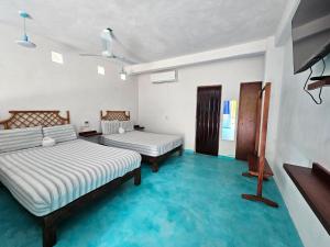 a bedroom with two beds and a blue floor at Departamento Turquesa in Barrio Nuevo