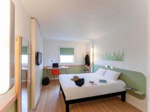 a hotel room with a bed and a desk at Ibis Budget Valencia Aeropuerto in Manises +42 photos
