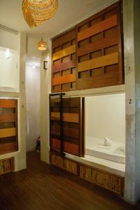 a bedroom with a bed in a room with wooden doors at Happiness Hostel El Nido in El Nido
