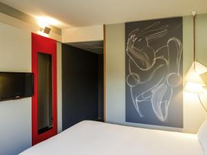 a bedroom with a bed and a painting on the wall at Hotel ibis Porto Sao Joao in Porto