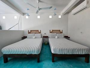 two beds sitting next to each other in a room at Departamento Turquesa in Barrio Nuevo +6 photos