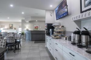 a kitchen with a counter and a dining room at Amsterdam Inn & Suites, an Ascend Collection Hotel in Moncton