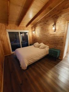 a bedroom with a bed in a wooden room at Entre Bosque Puelo in Puelo
