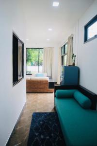 a living room with a green couch in a room at Thalang Home in Thalang