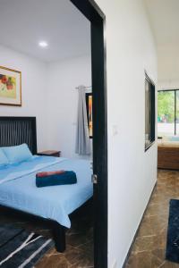 a bedroom with a bed and a door leading to a bathroom at Thalang Home in Thalang