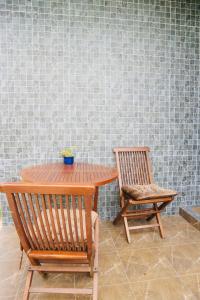 a wooden table and two chairs next to a wall at Thalang Home in Thalang