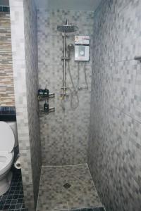 a bathroom with a shower with a toilet at Thalang Home in Thalang +17 photos