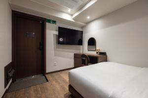 a hotel room with a bed and a flat screen tv at Onjae Stay Seongsu in Seoul