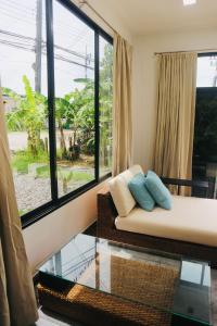 a living room with a couch and a glass table at Thalang Home in Thalang