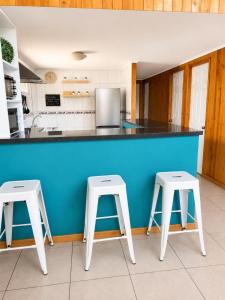 a kitchen with two white stools and a blue counter at Casa en Santiago equipada in Santiago