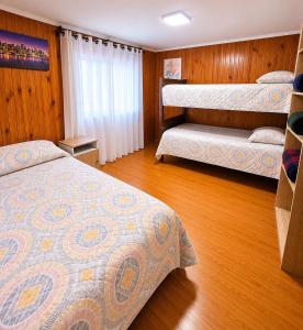 a bedroom with two beds and a wooden floor at Casa en Santiago equipada in Santiago
