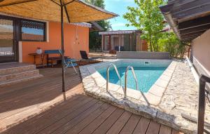 a swimming pool with an umbrella next to a house at Awesome Home In Karlovac in Karlovac +19 photos