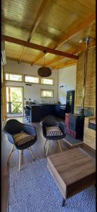 a living room with two chairs and a table at Entre Bosque Puelo in Puelo