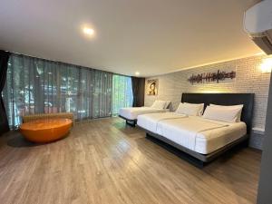 a bedroom with two beds and a large window at BB Glass House Pattanakrn บีบี กลาสเฮ้าส์ พัฒนาการ in Bangkok