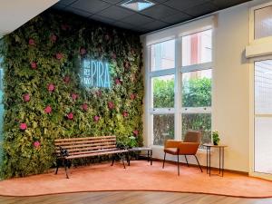 a wall covered in flowers with a bench and two chairs at ibis Piracicaba in Piracicaba