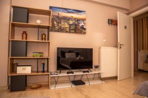 a living room with a tv and a table at Stylida Apartment - Ocean Air & Quiet Nights! in Stilís