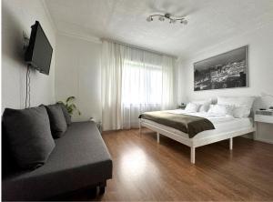 a white bedroom with a bed and a couch at Refugium 2020 in Marienheide