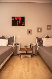 a living room with two beds and a table at Stylida Apartment - Ocean Air & Quiet Nights! in Stilís