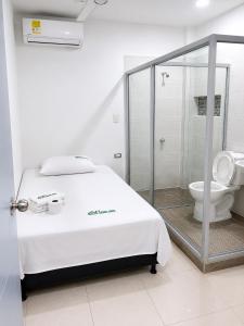 a bedroom with a bed and a shower and a toilet at Casa Hotel Ortiz in Apartadó