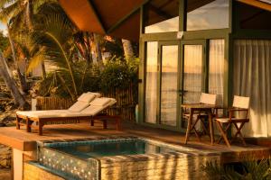 a house with a swimming pool next to a table at Kama Haven in Semaya