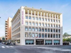 a large white building on the corner of a street at Mercure Roma Piazza Bologna in Rome