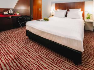 a large white bed in a hotel room at Mercure Roma Piazza Bologna in Rome