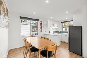 a kitchen with a wooden table and chairs and a refrigerator at Ingenia Holidays Torquay Australia in Torquay