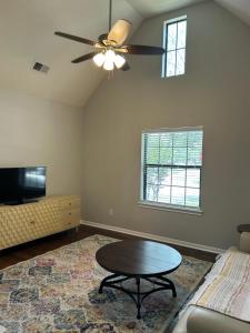 a living room with a ceiling fan and a coffee table at Lovely Boho Chic Garden Home in Spring +7 photos