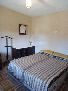 a bedroom with a bed with a dresser and a mirror at El PRADO in Alta Gracia