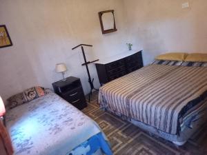a bedroom with two beds and a mirror and a table at El PRADO in Alta Gracia