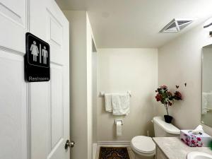 a white bathroom with a toilet and a sink at Comfortable 2BR Getaway with Extra Lounge Space in Toronto